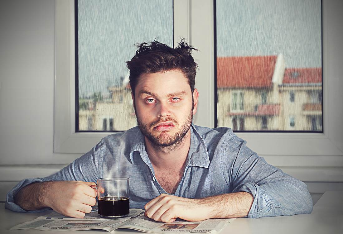 Alkoholpause: Das passiert schon nach einem Monat mit deinem Körper! Verkaterter Mann mit Tasse Tee