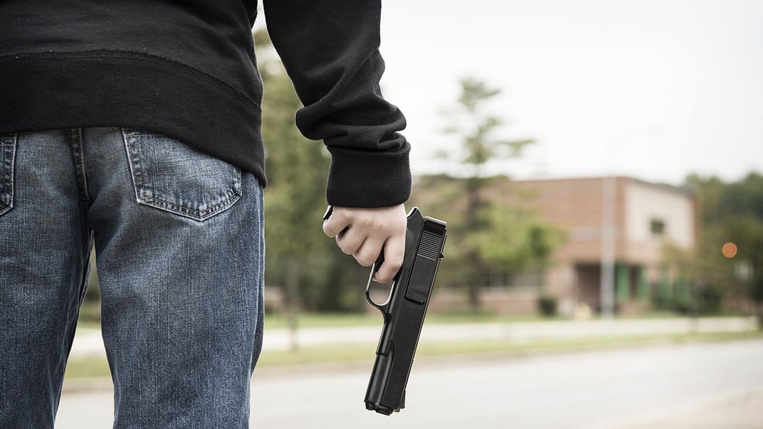 Junger Mann mit einer Pistole  - Foto: iStock / Brycia James