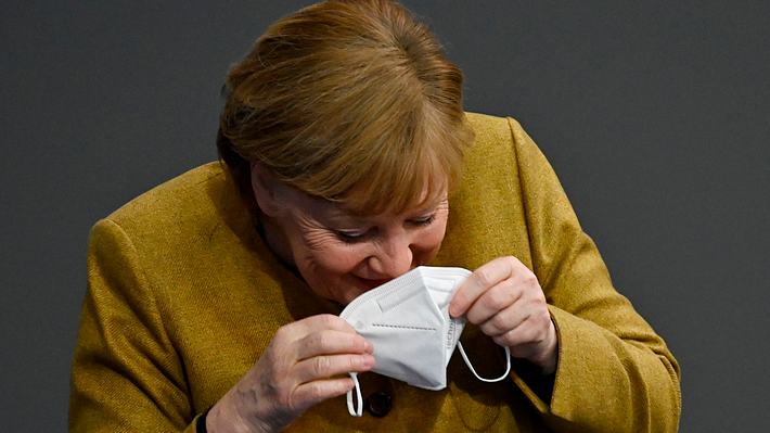 Angela Merkel lacht in ihre Mundschutzmaske hinein - Foto: Getty Images / Tobias Schwarz