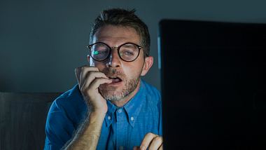 Mann guckt auf Laptop - Foto: iStock/Marcos Calvo