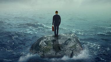 Mann auf Felsen im Meer - Foto: iStock/SIphotography