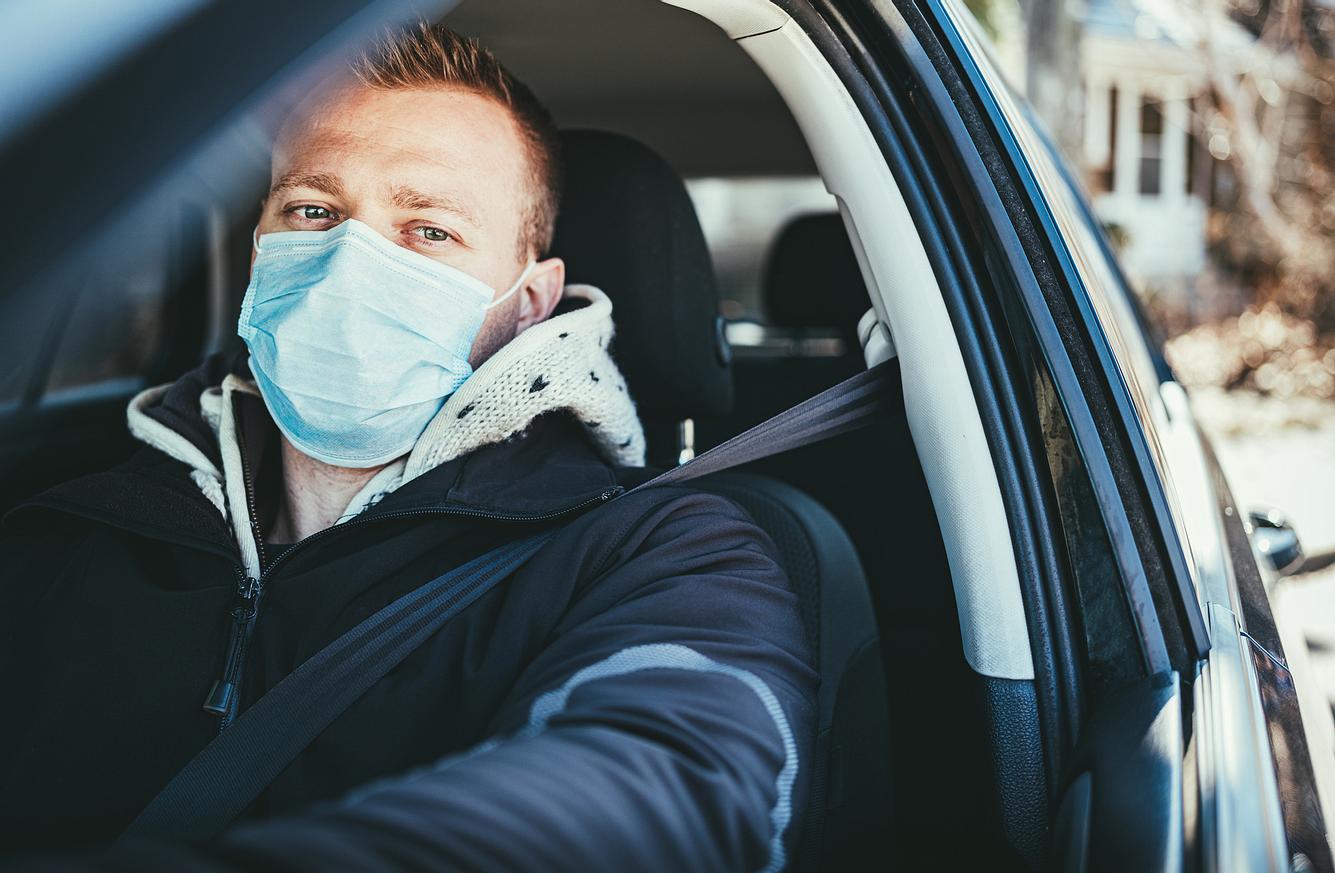 Erstes Bundesland führt Maskenplicht auch für Autofahrer ein Mann mit Schutzmaske im Auto