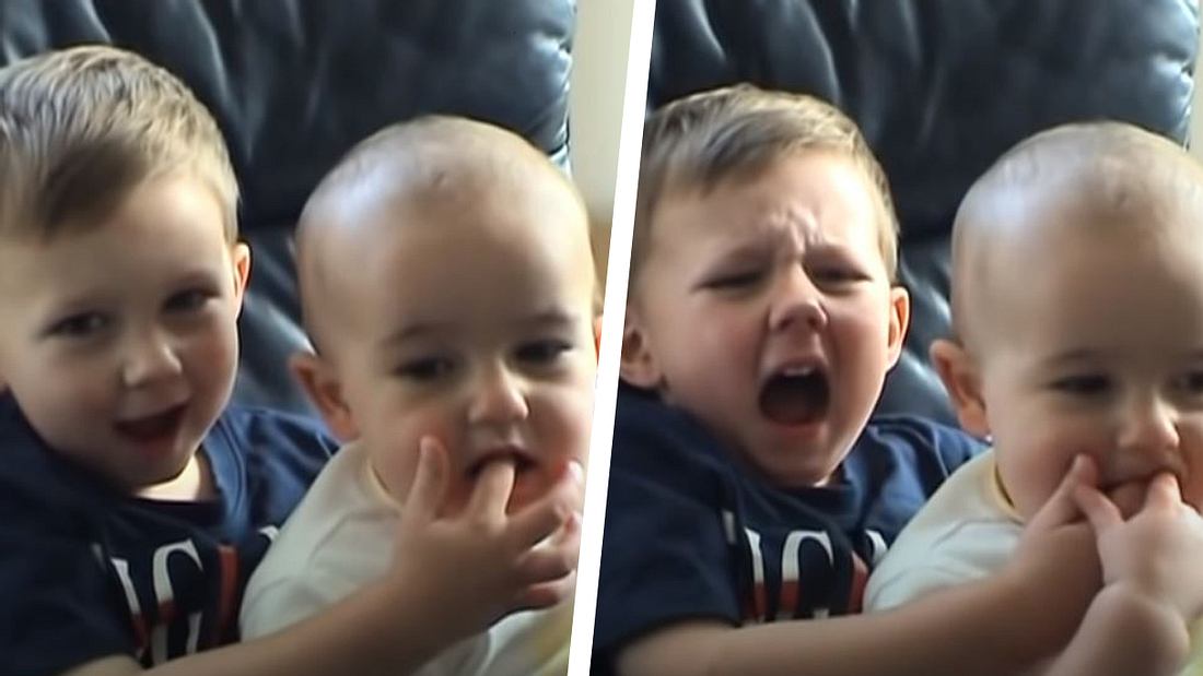 Baby beißt seinem Bruder in den Finger