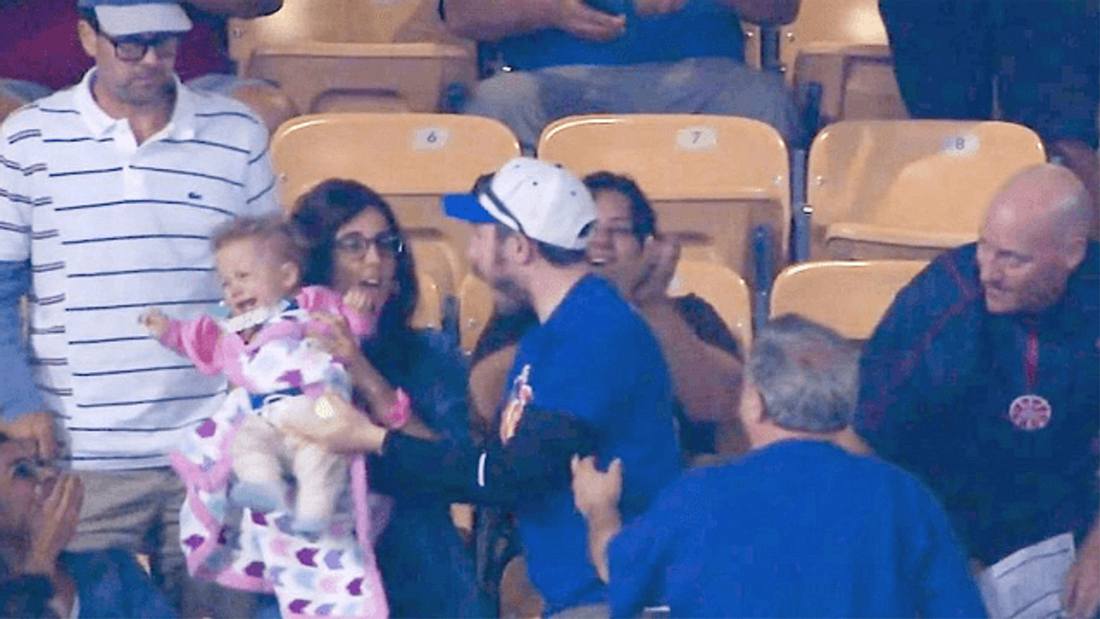Mets vs. Dodgers: Ein Baseball-Fan versucht den Ball mit seinem Baby auf dem Arm zu fangen