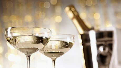 Zwei mit Schaumwein gefüllte Champagnergläser - Foto: iStock/Silberkorn