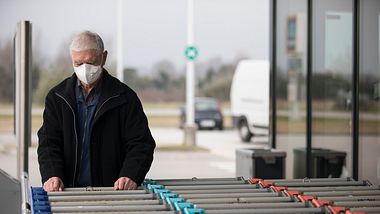 Mann mit Maske am Einkaufswagen  - Foto: iStock / :kmatija