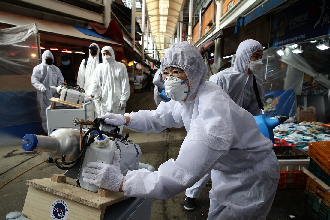 Coronavirus: Erste positive Nachrichten aus Asien Menschen mit Mundschutz und Schutzanzügen