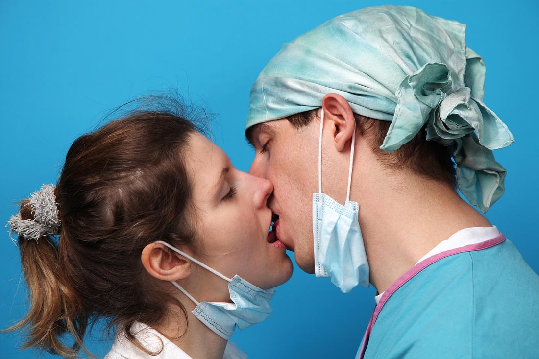 Liebe in Zeiten des Coronavirus Pärchen mit Mundschutz küsst sich