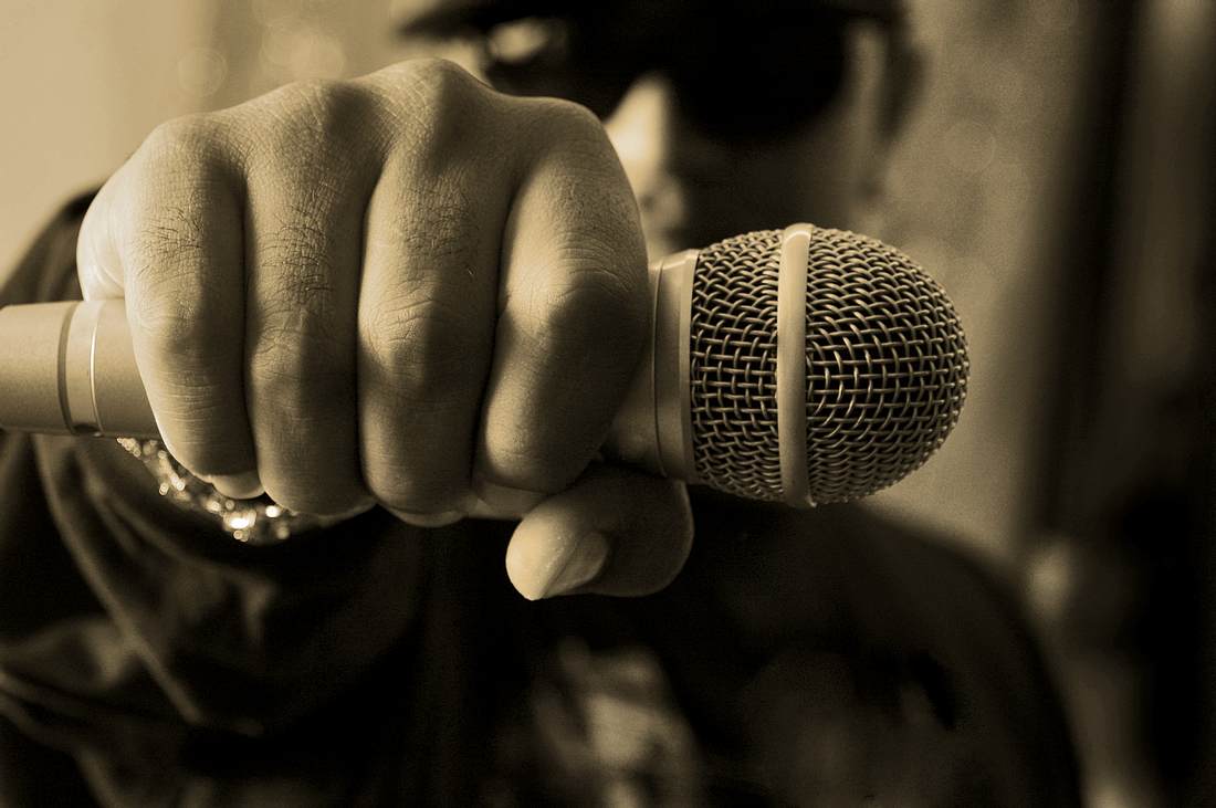 Das Corona-Urteil: Deutschrapper disst Covid-19 Rapper hält Mikrofon in die Kamera