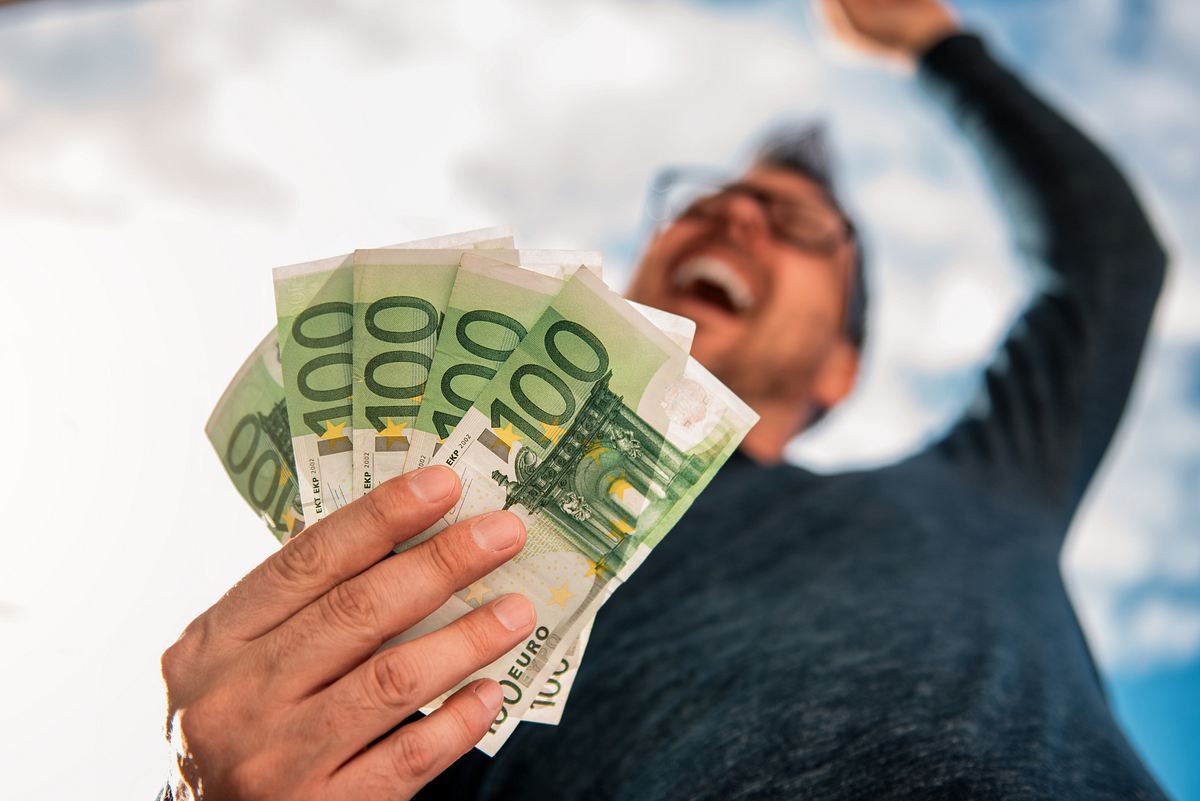 Glücklicher Mann mit fünf 100-Euro-Scheinen in der Hand