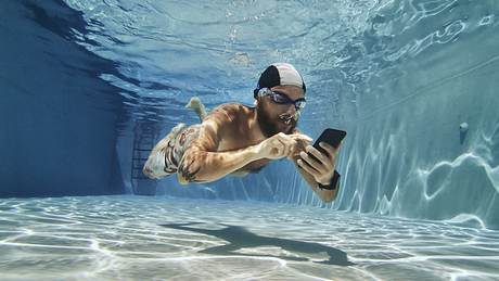 Mann mit Handy im Pool - Foto: iStock/piola666