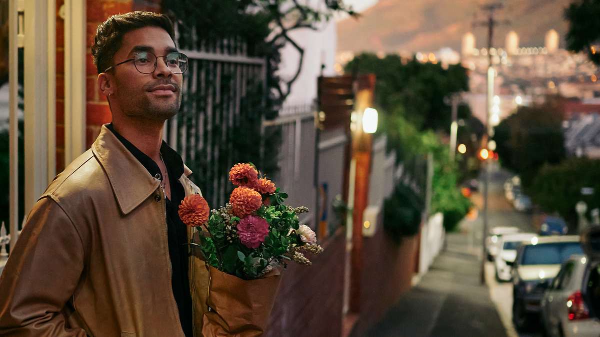 Mann wartet mit Blumen in der Hand