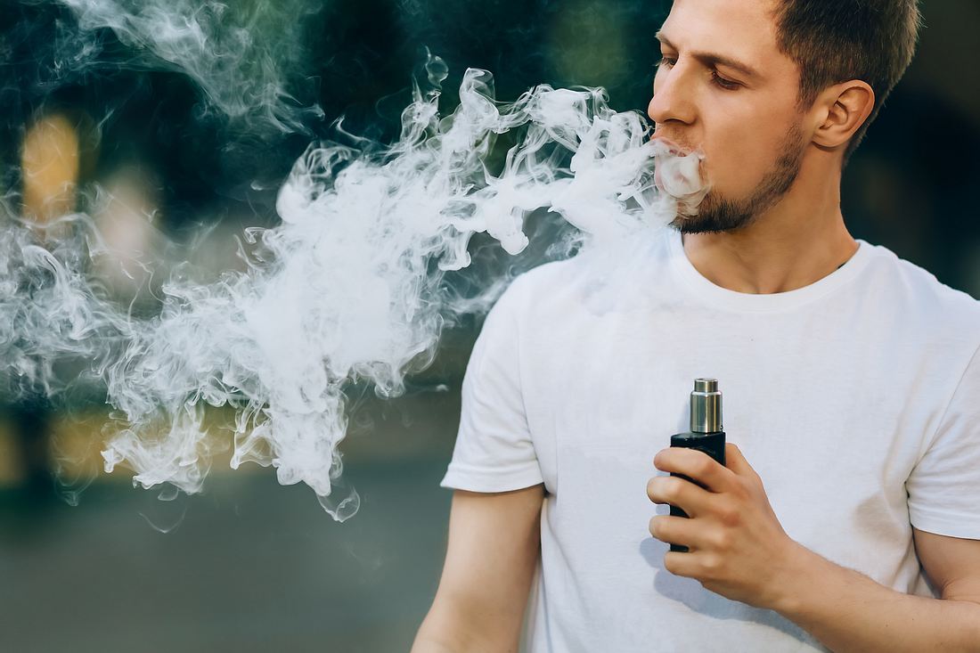 Junger Mann mit E-Zigarette