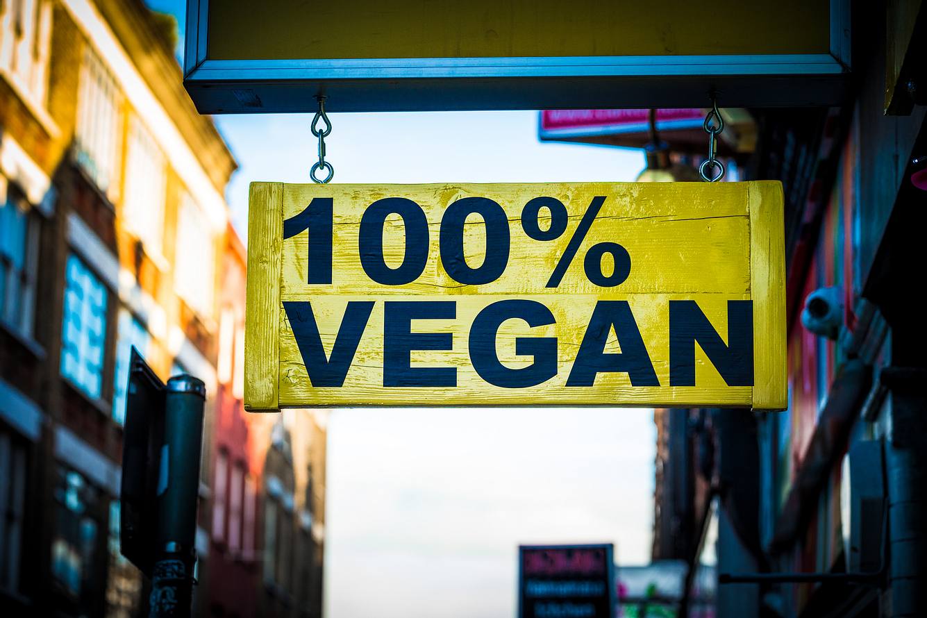 Firma zahlt Fleischessern 55.000 Euro – wenn sie 3 Monate vegan leben! Schild mit der Aufschrift 100% VEGAN