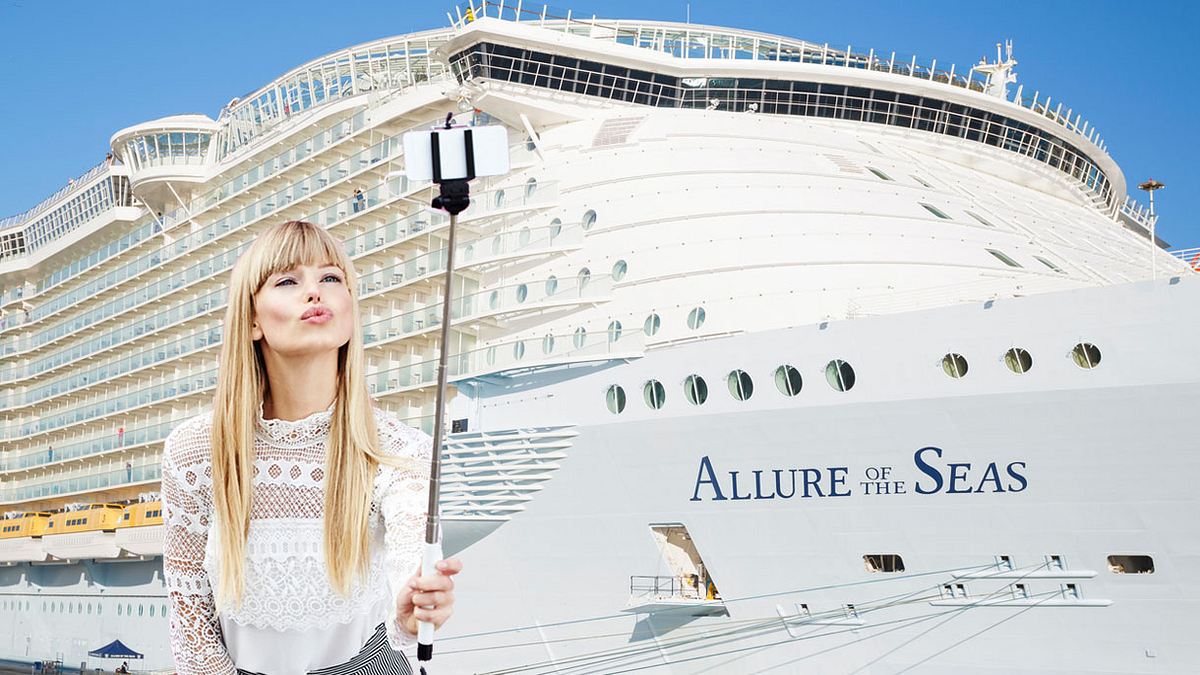 Frau macht Selfie vor Kreuzfahrtschiff