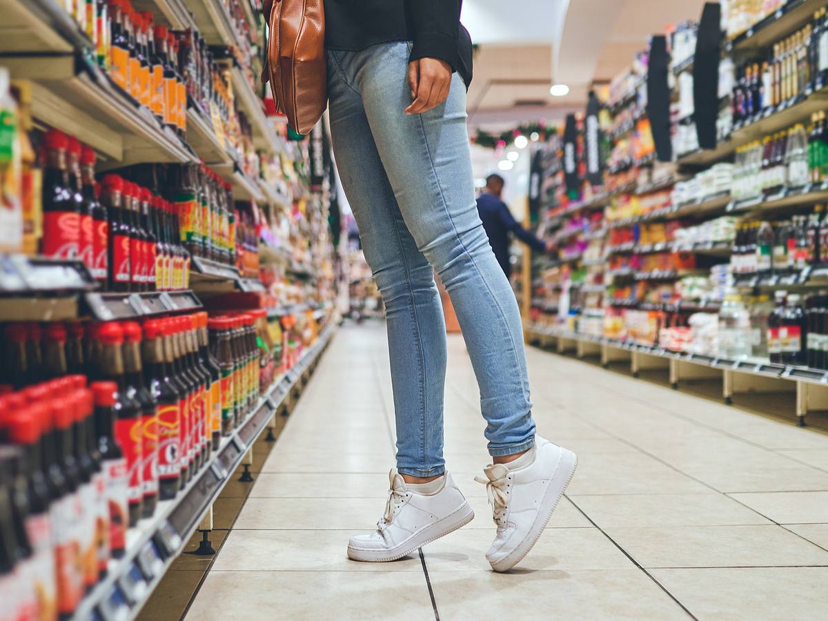 Frau steht am Supermarktregal