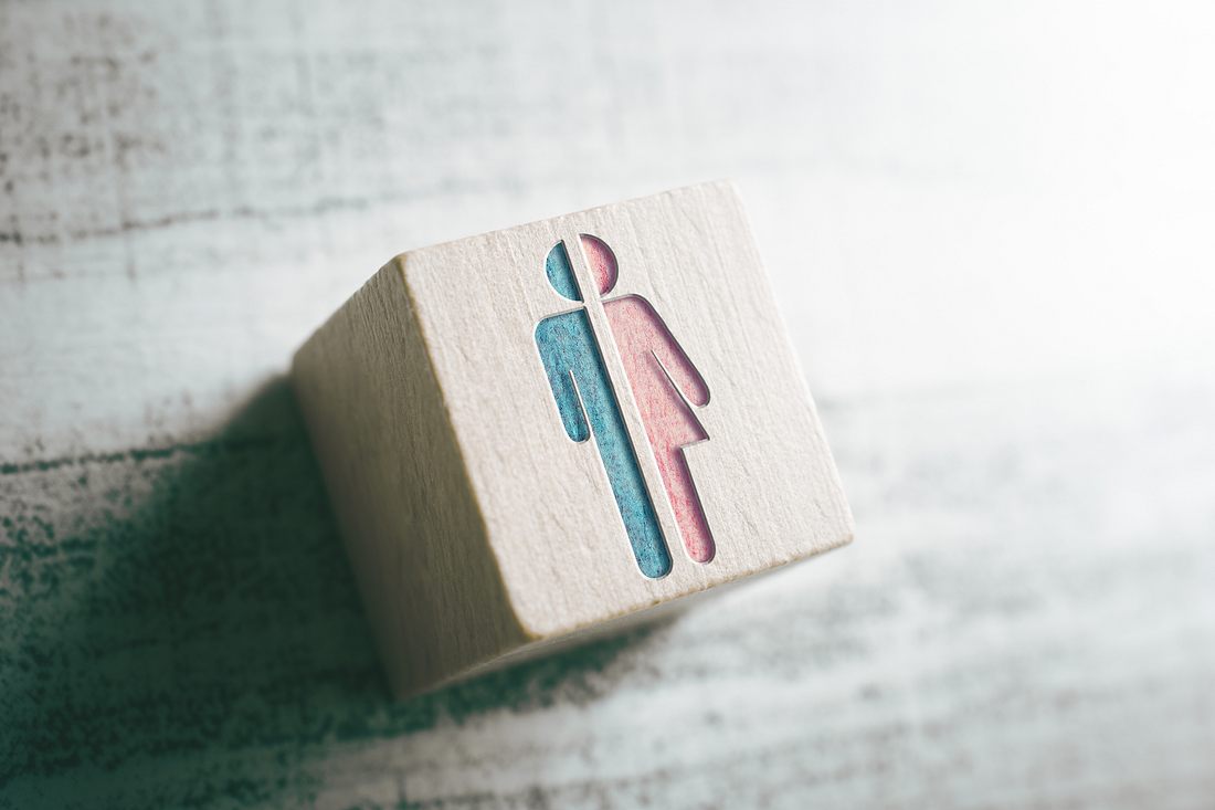Geschlechtersymbole auf einem Holzblock