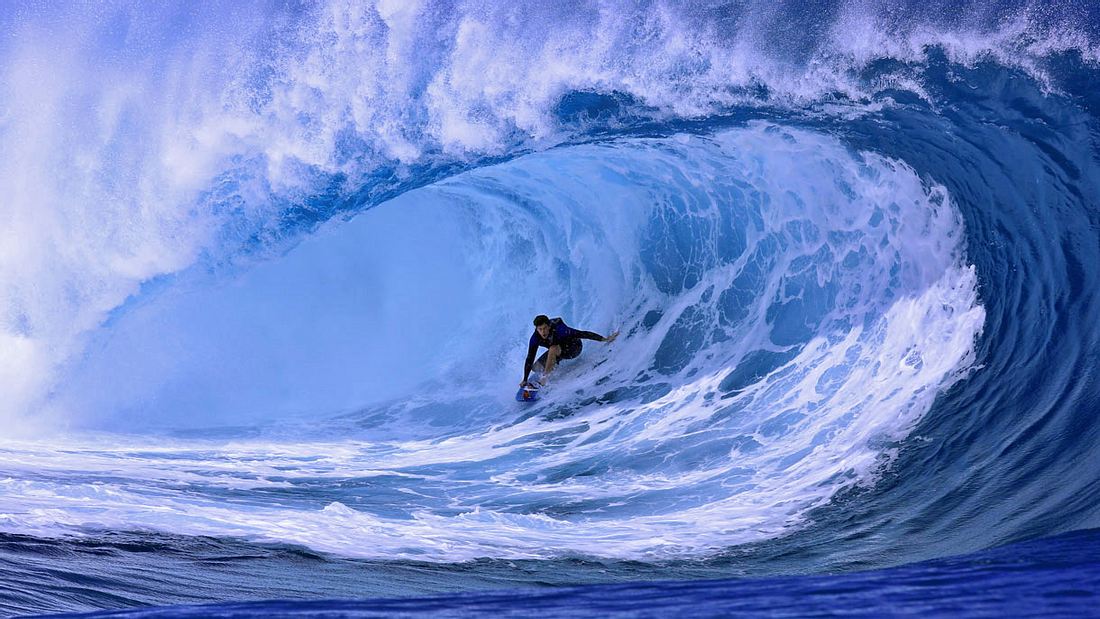 Ein Surfer reitet die Welle von Teahupoo Ein Surfer reitet die Welle von Teahupoo