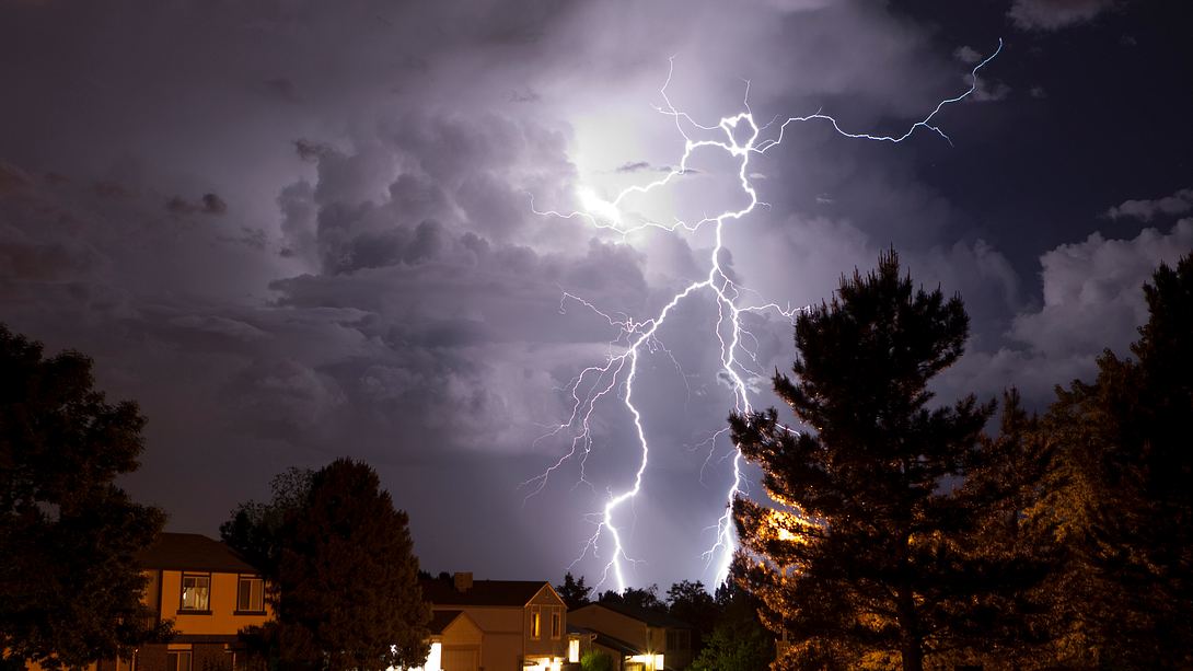 Unwetter mit Blitzen über Siedlung - Foto: iStock / milehightraveler