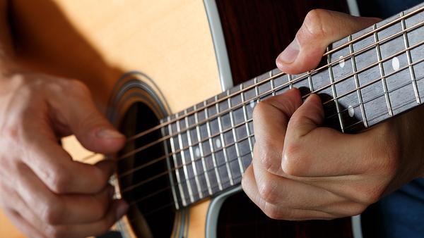 Mann spielt Akustikgitarre - Foto: iStock/Dutko