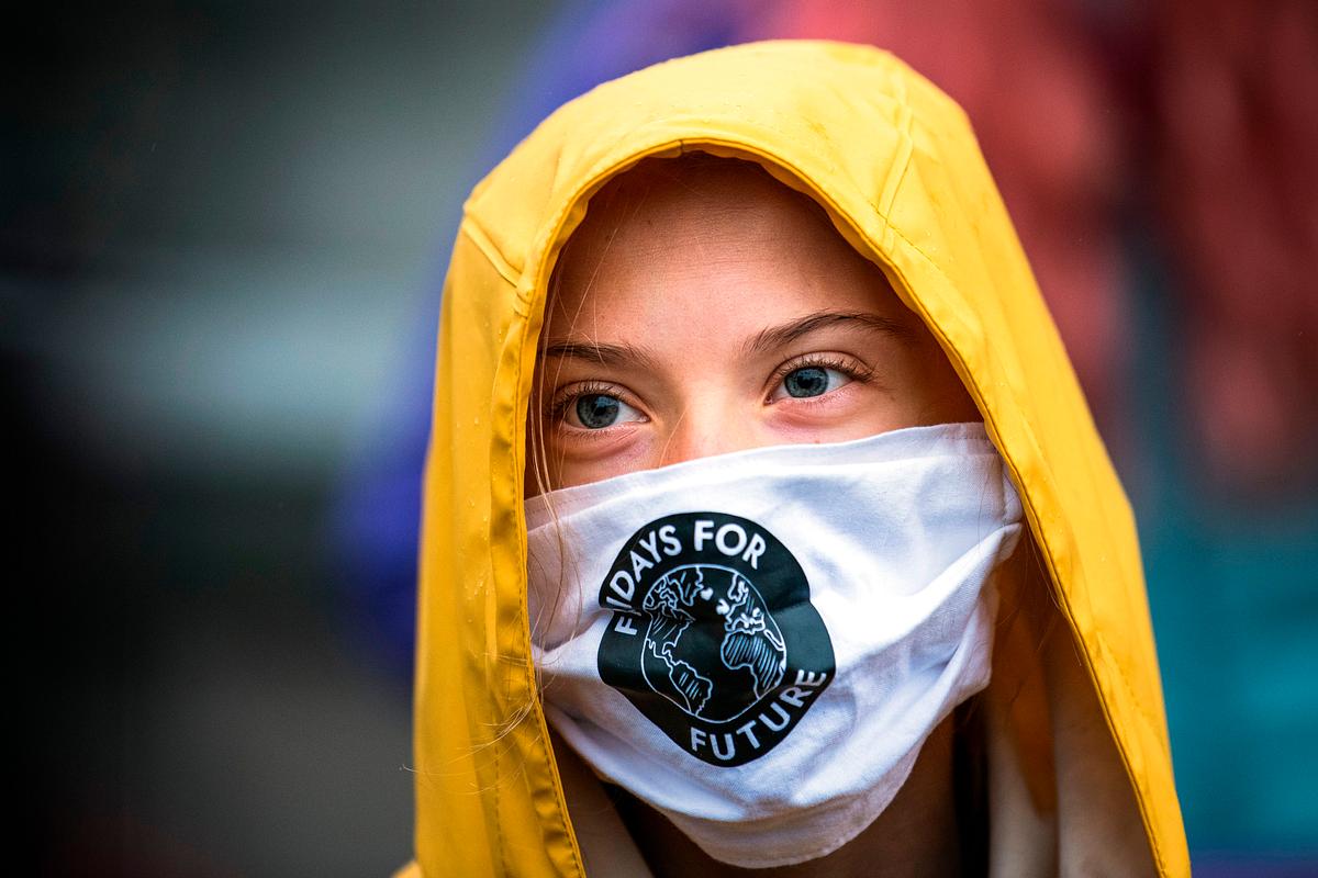 Greta Thunberg mit gelber Regenjacke und Mundschutzmaske