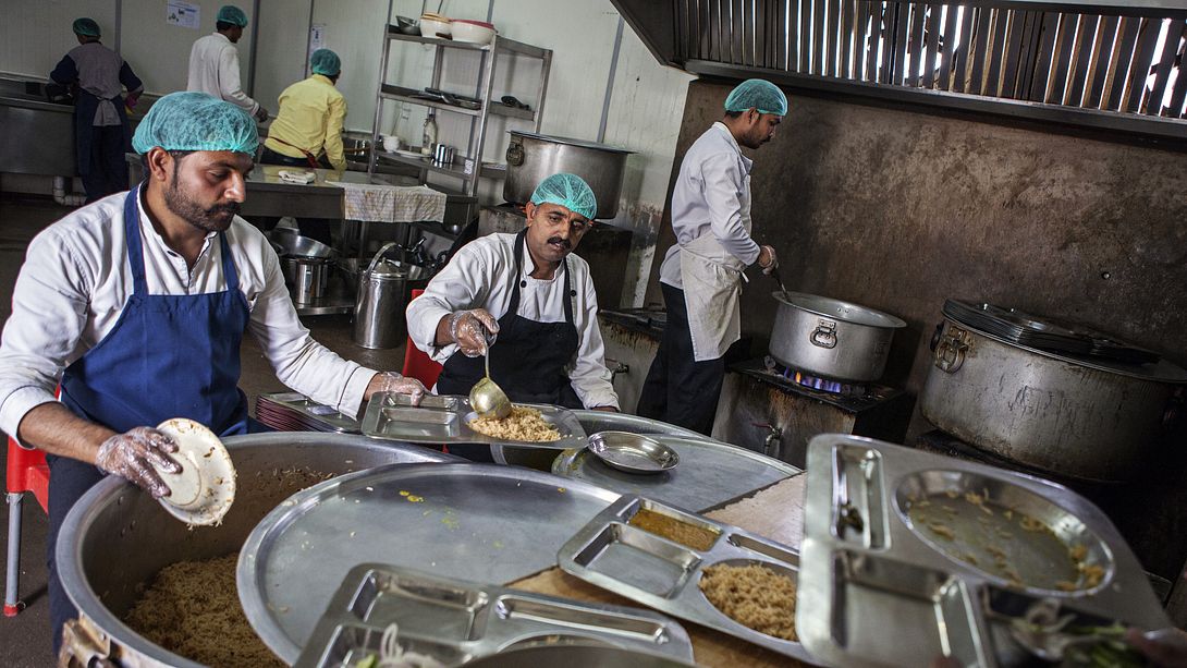 Großküche mit Köchen vor riesigen Töpfen - Foto: Getty Images / Asim Hafeez / Bloomberg