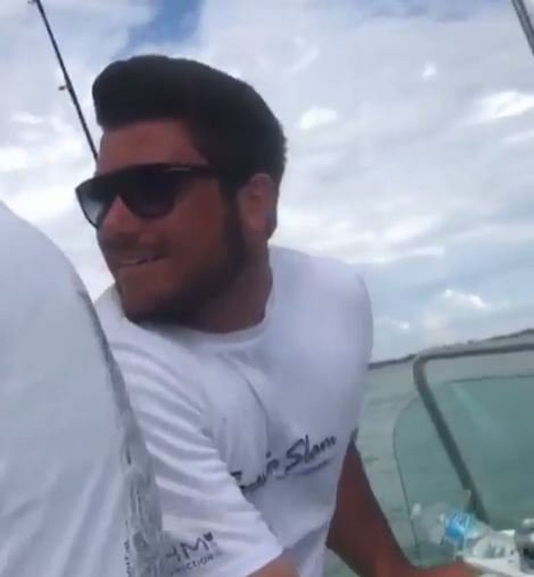 Ein Hai wird von einer Gruppe Männern hinter einem Speedboot hergezogen