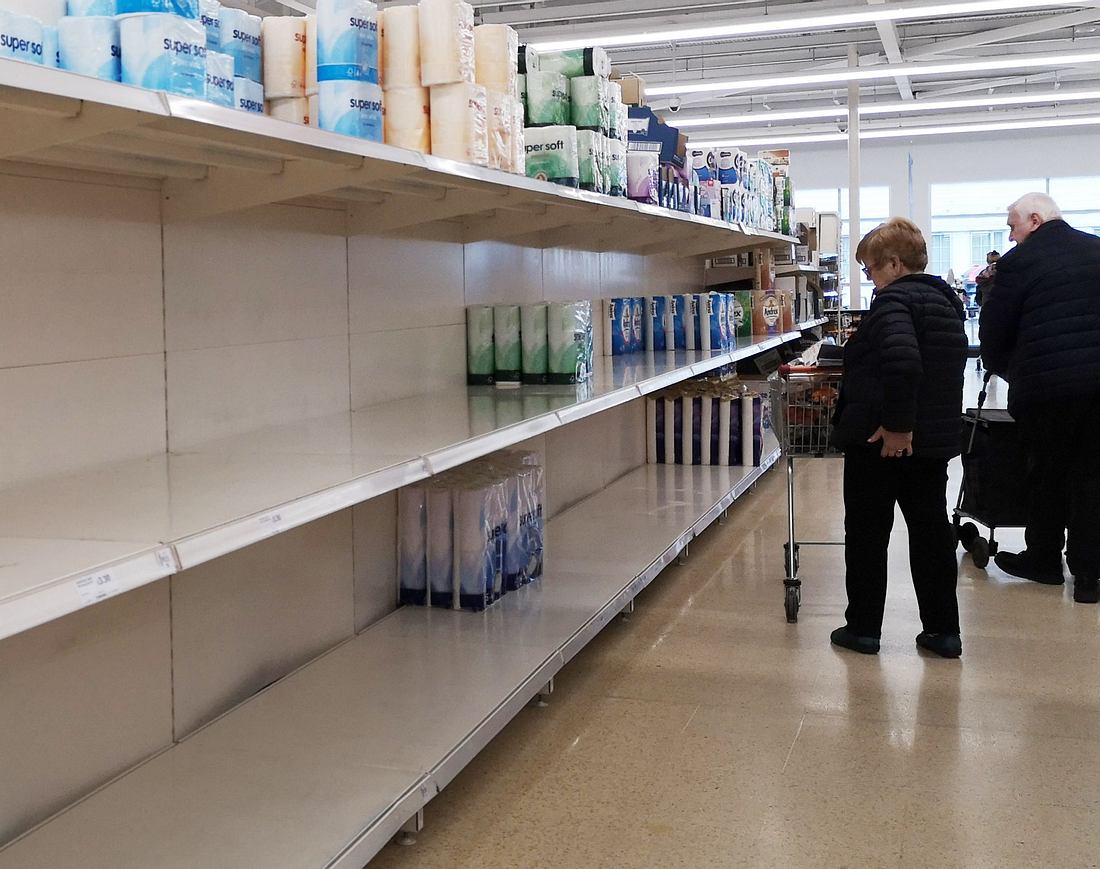 Hamsterkäufe: Supermärkten droht bis zu 25.000 Euro Strafe Zwei Supermarkt-Kunden stehen vor einem leeren Verkaufsregal