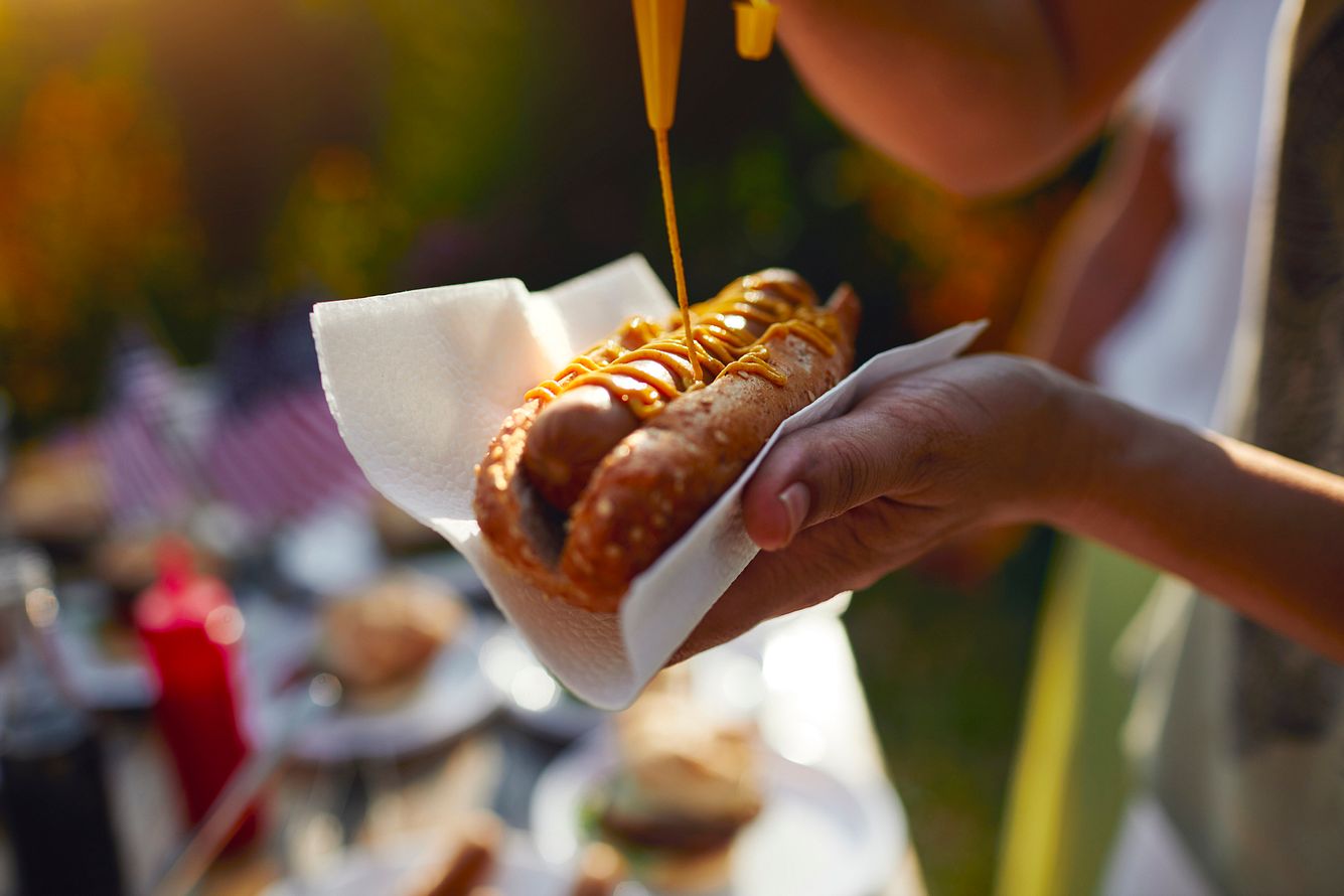 Wie im Märchen: Mann isst Hot Dog in Schnell-Restaurant - hinterlässt Mega-Trinkgeld Mann macht sich Senf auf einen Hotdog