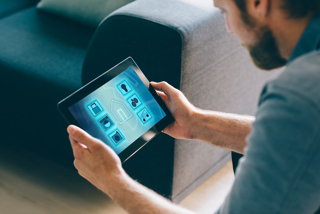 Alle was du über Smart Home Geräte wissen musst Mann konfiguriert seine Smart Home Geräte auf I-Pad