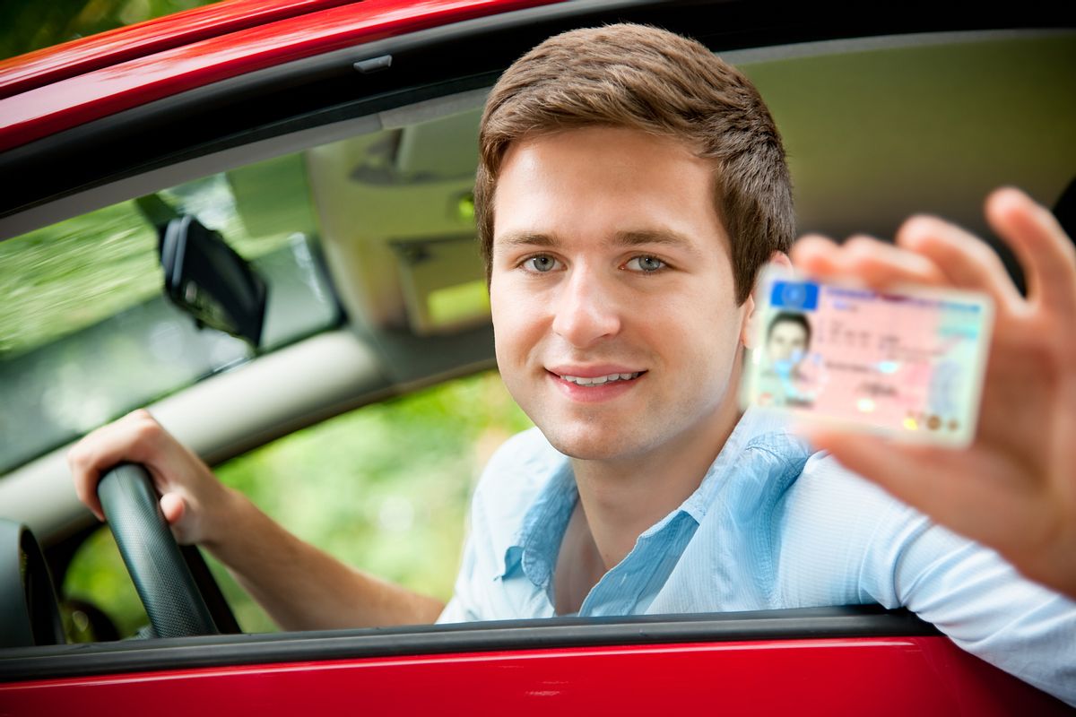 Junger Mann zeigt freudestrahlend seinen Führerschein