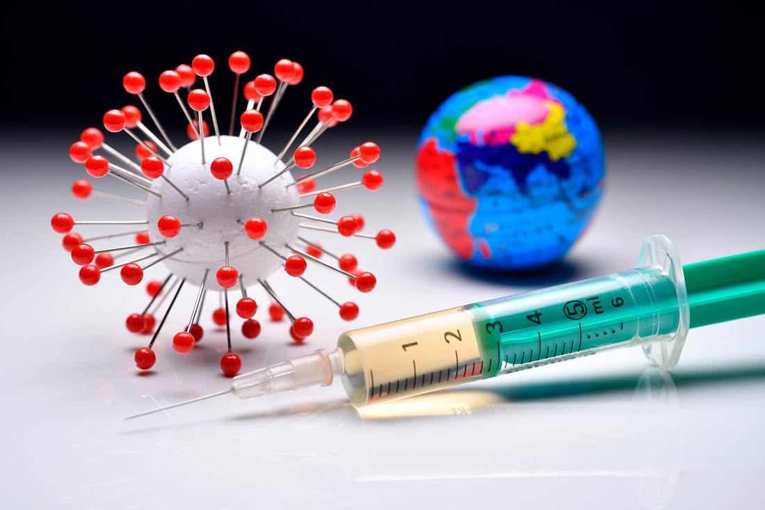 Impfpflichten weltweit Ein Coronavirus-Modell, eine Erdkugel und eine Impfspritze