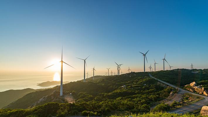 Windräder in einer Landschaft - Foto: iStock / yangphoto