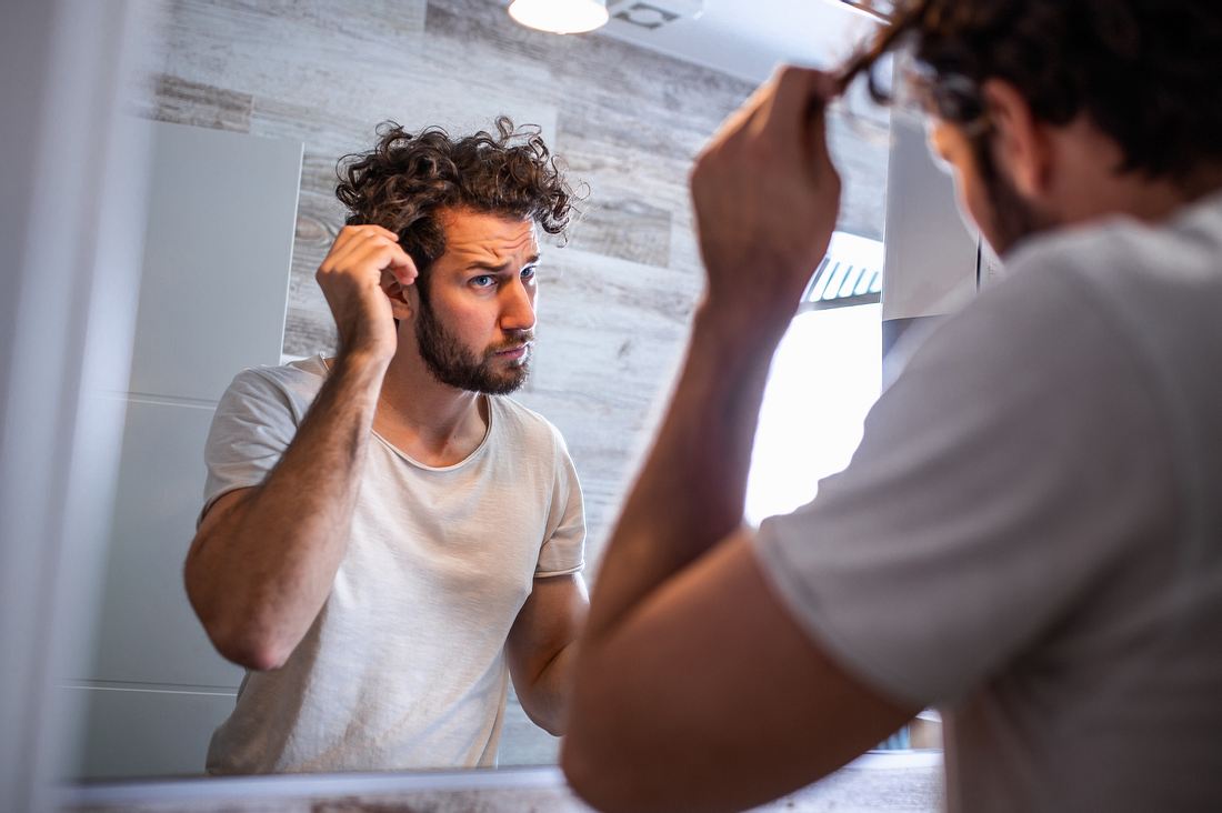 Mann überprüft seine Haare