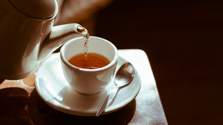 Tea cup on saucer, with tea being poured, - Foto: iStock / WiroKlyngz