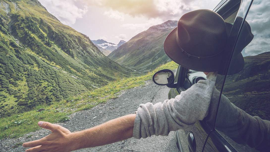Mann hält Hand aus dem Auto - Foto: iStock / swissmediavision