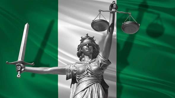 Statue des Gottes der Gerechtigkeit Themis vor der Flagge Nigerias