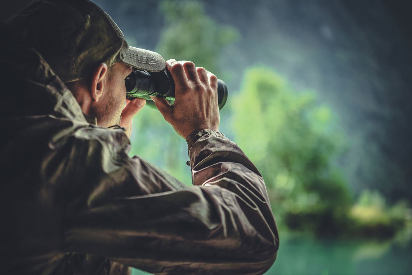 Jäger guckt durch Fernglas