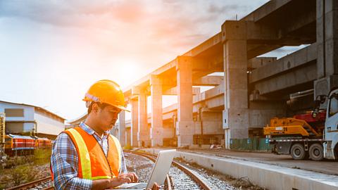 Mann mit Laptop auf Baustelle  - Foto: iStock / DSCimage