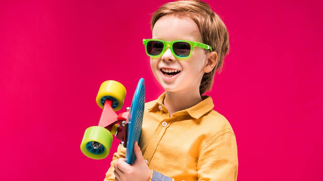 Junge mit Sonnenbrille und Skateboard - Foto: iStock/LightFieldStudios