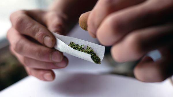 Mann dreht sich einen Joint - Foto: iStock / Roman Budnyi