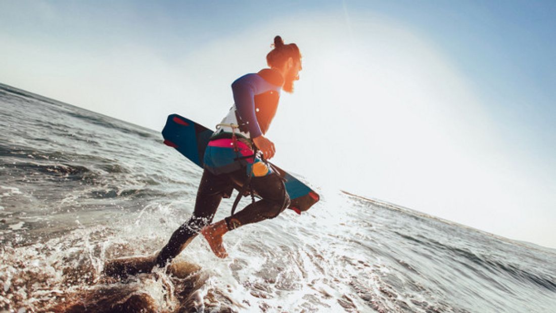 Kiteboards gibt es in vielen verschiedenen Ausführungen Kiteboard Strand Mann