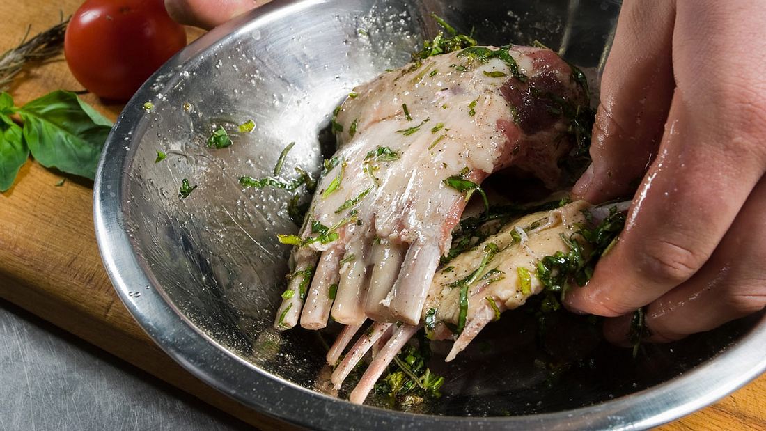 Lammkarree in frischen Kräutern, Knoblauch und Öl marinieren Lammkarree in frischen Kräutern, Knoblauch und Öl marinieren