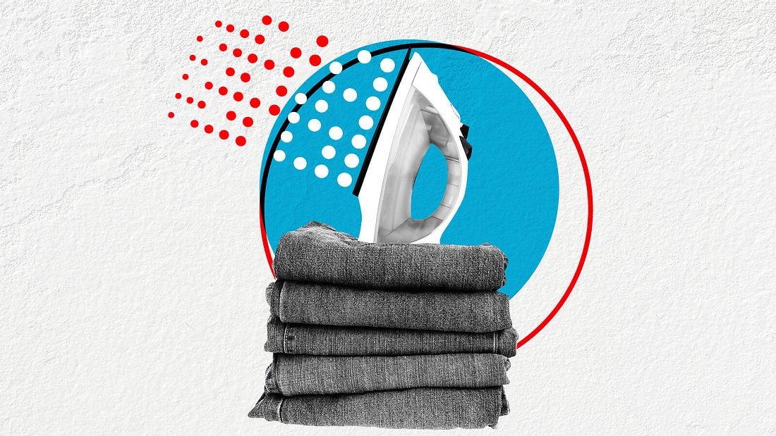 Jeans bügeln Bügeleisen über einem Stapel Jeans