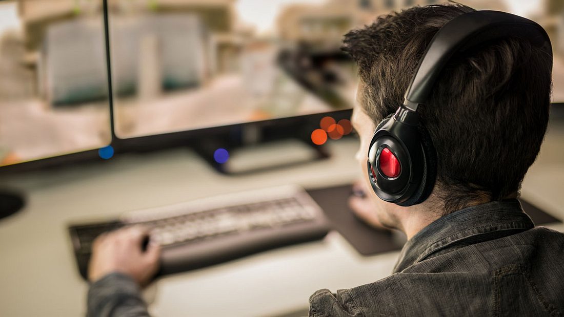 Mann sitzt am PC und spielt Mann sitzt am PC und spielt