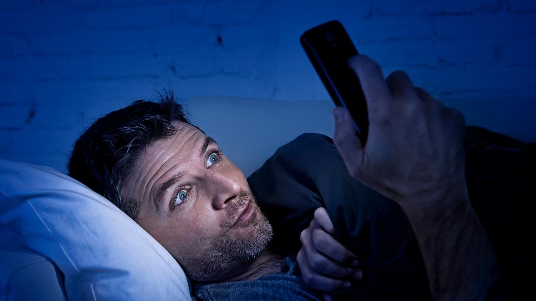 Mann schaut Pornos auf seinem Handy - Foto: iStock / OcusFocus
