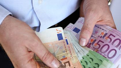 Mann mit Geldscheinen  - Foto: iStock / Mikosch