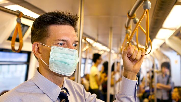 Mann mit Mundschutz in der U-Bahn - Foto: iStock / joakimbkk