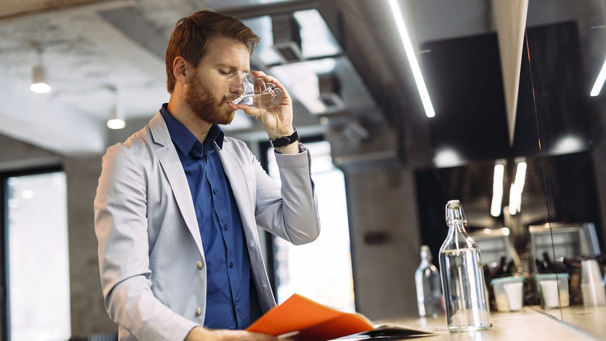 Mann trinkt lässig eine Glas Wasser