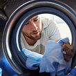 Mann wäscht seine dreckige Wäsche - Foto: iStock / monkeybusinessimages